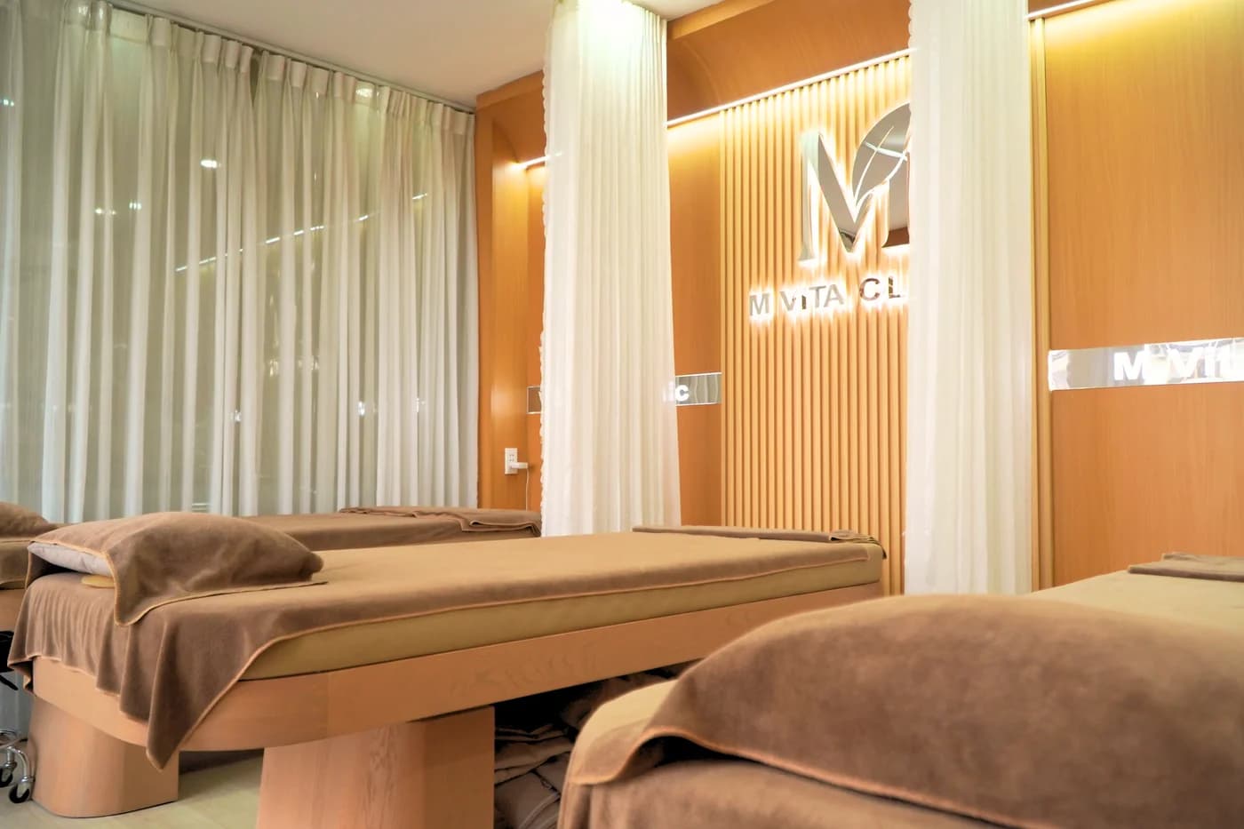 Phòng chăm sóc MVita với giường, rèm ngăn và ánh sáng ấm